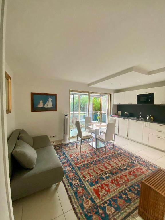 un salon avec un canapé et une table dans l'établissement Lovely Flat with Covered Balcony in Cannes, à Cannes