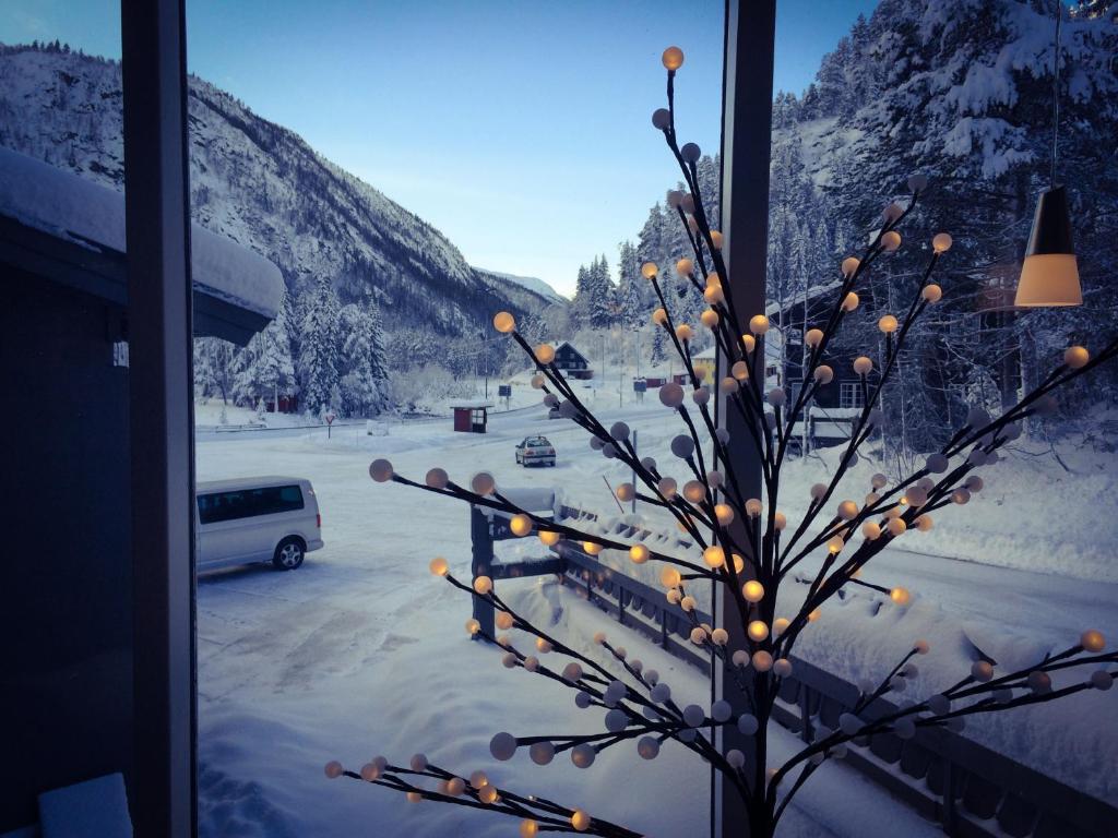 een kerstboom voor een raam met lichten bij Haukeli Hotel in Haukeligrend