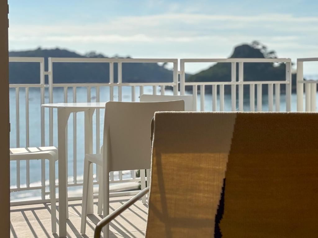 une table et des chaises sur un balcon avec l'océan dans l'établissement le taureau - T3, à Trébeurden