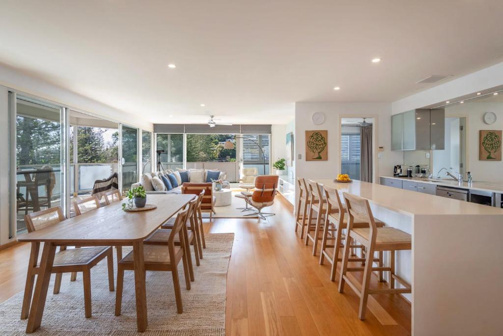 Una cocina y una sala de estar con mesa y sillas. en Penthouse on the Ritz - Oceanstays, en Yamba