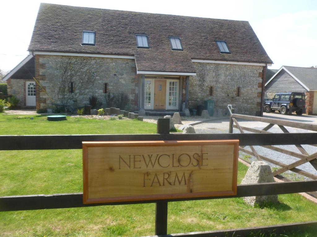 a wooden sign in front of a house at The Old Barn, Newclose Farm in Yarmouth