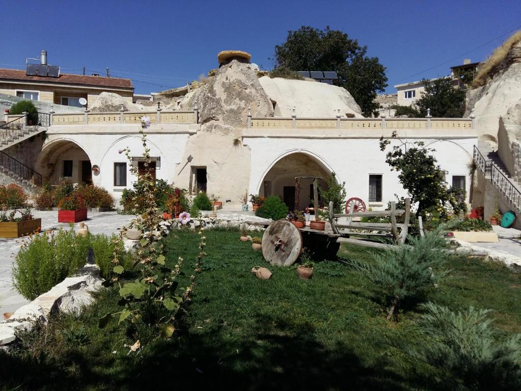 una casa antigua con un jardín delante de ella en Ortahisar Cave Hotel, en Ortahisar