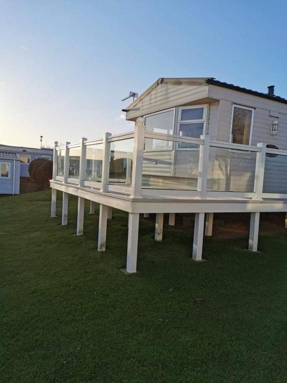 a house with a porch on top of a yard at Haven Devon Cliffs Caravan in Budleigh Salterton