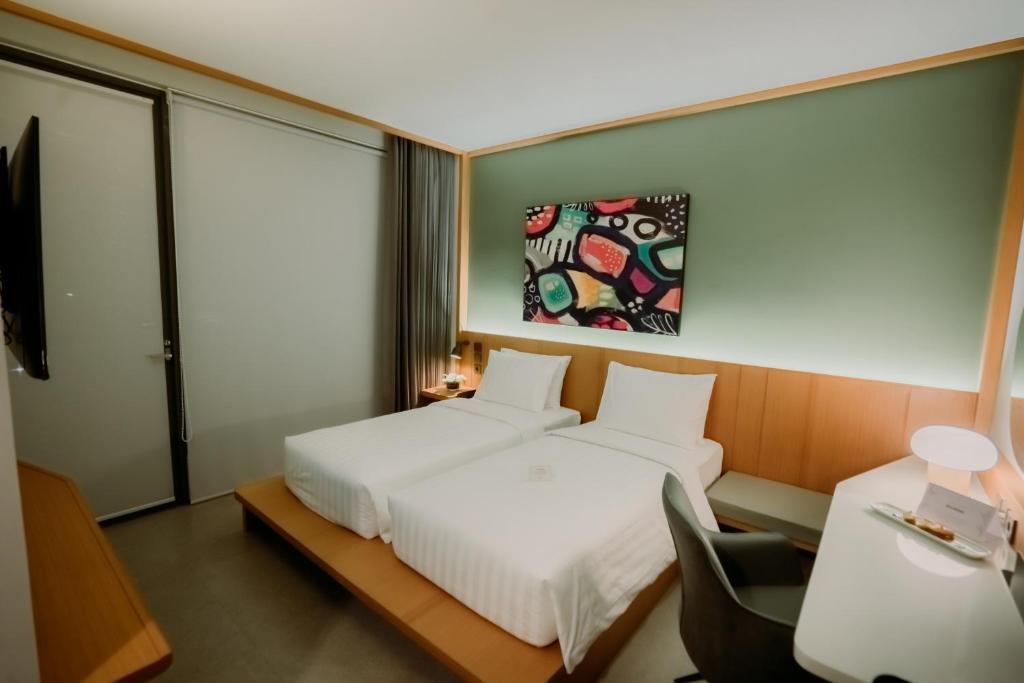 Postel nebo postele na pokoji v ubytování Jiro Hotel