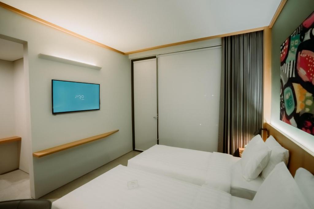 Postel nebo postele na pokoji v ubytování Jiro Hotel