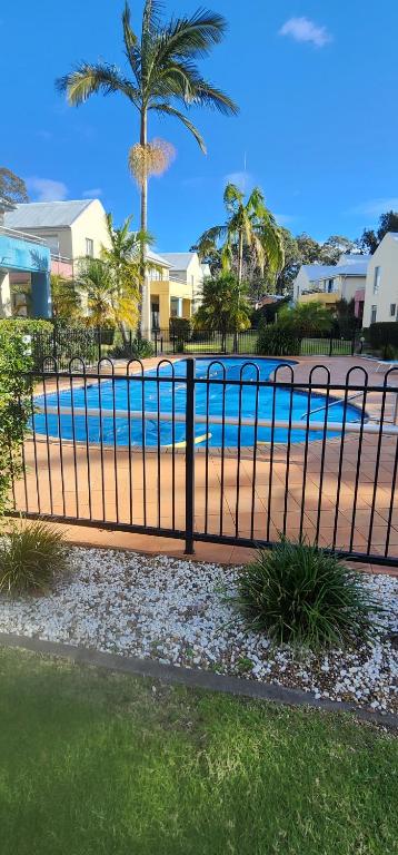 a black metal fence next to a swimming pool at Bec's Beach House Getaway in Batemans Bay