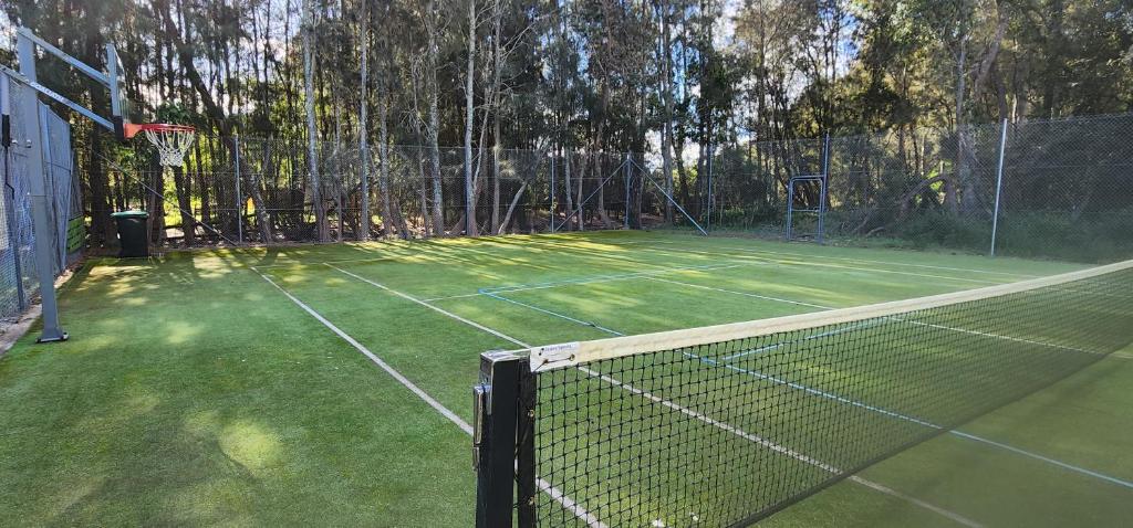a tennis court with a net on top of it at Bec's Beach House Getaway in Batemans Bay