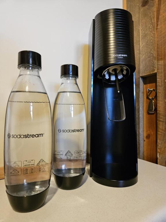 two bottles on a counter next to a blender at The Gamekeepers Spa Cottage in Tamborine Mountain in Mount Tamborine