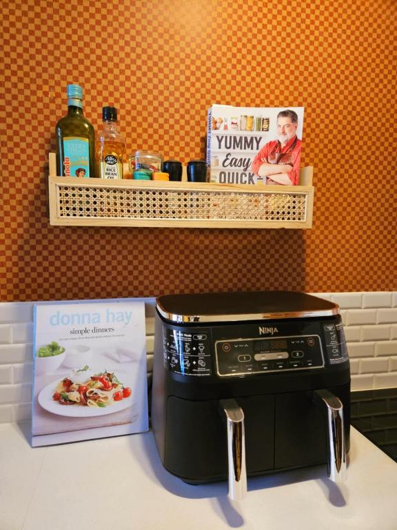 a microwave sitting on a counter next to a book at The Gamekeepers Spa Cottage in Tamborine Mountain in Mount Tamborine