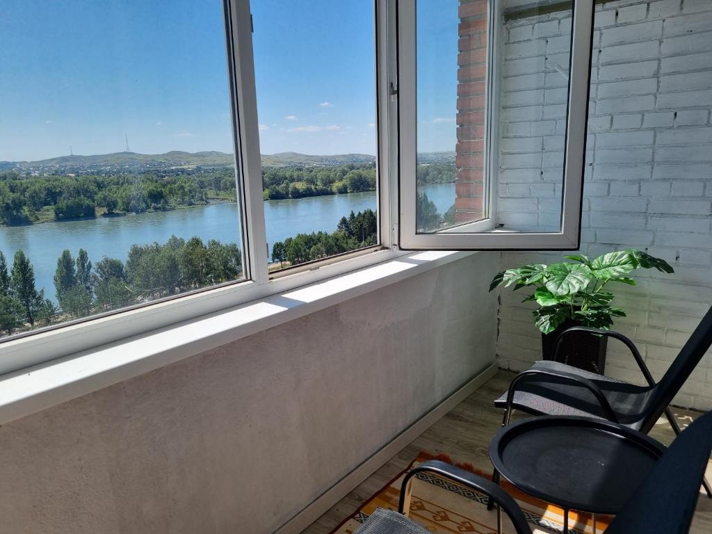 a room with three windows with a view of a river at Набережная Иртыша с красивым видом на реку in Ustʼ-Kamenogorsk