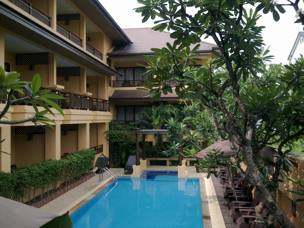 um hotel com piscina em frente a um edifício em La Maison Hua Hin em Hua Hin