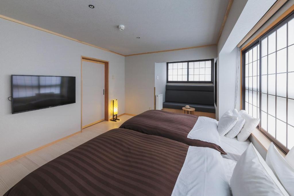 Postel nebo postele na pokoji v ubytování Takamiya Ryokan Miyamaso