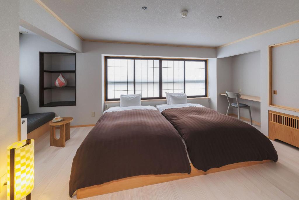 Postel nebo postele na pokoji v ubytování Takamiya Ryokan Miyamaso