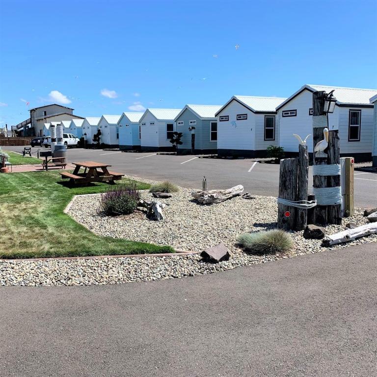 a parking lot with a park with a bench and houses at Westport Marina Cottages in Westport