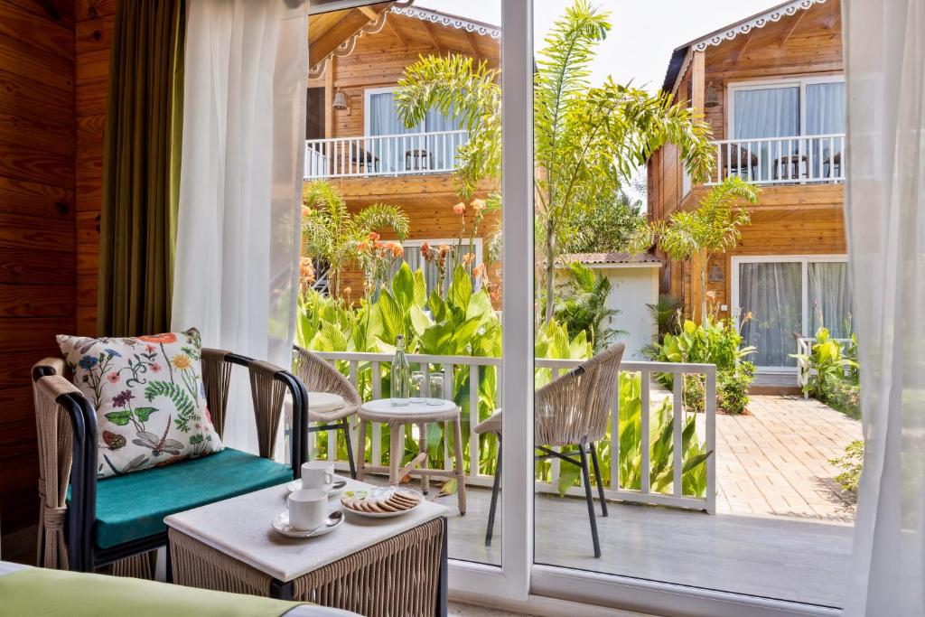 a room with a balcony with chairs and a table at Aralea Beach Resort By Stone Wood Premier in Morjim