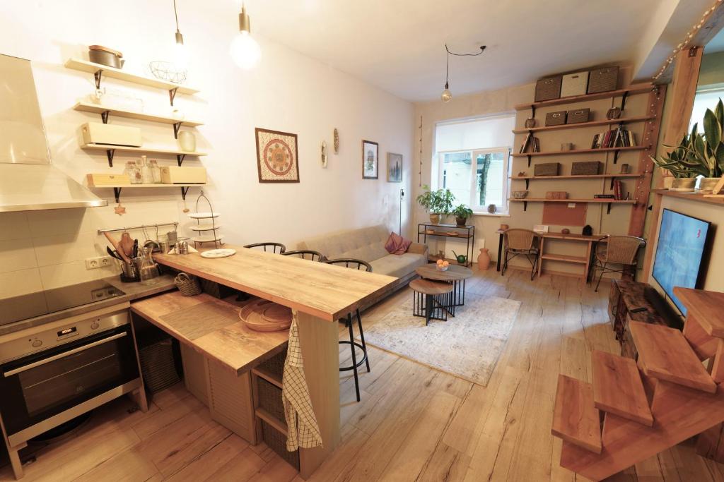 een keuken en een woonkamer met een houten tafel bij Jaukus Butas - Studija centre in Klaipėda