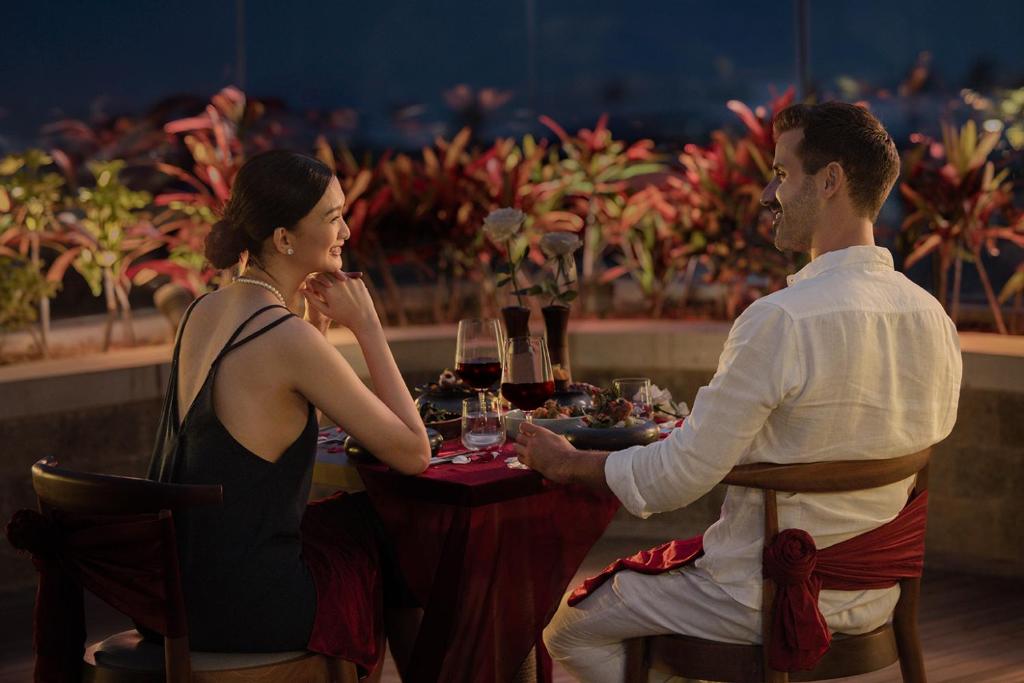 a man and woman sitting at a table in a restaurant at Holiday Inn Resort Bali Canggu by IHG in Canggu