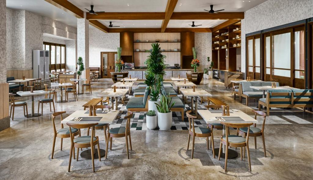 a restaurant with tables and chairs in a room at Holiday Inn Resort Bali Canggu by IHG in Canggu