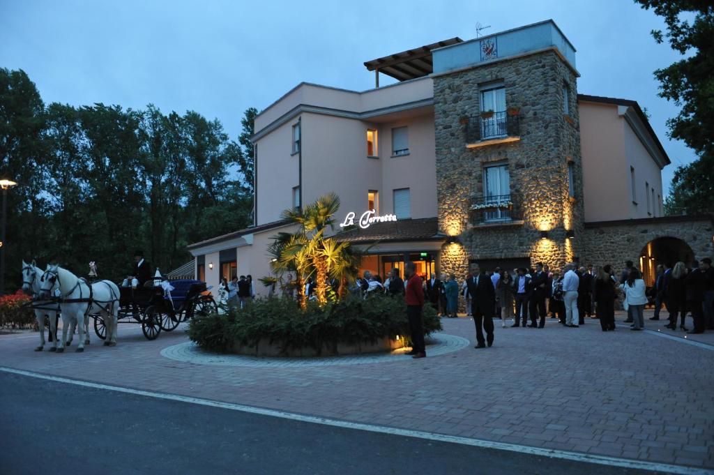 une calèche tirée par des chevaux devant un bâtiment dans l'établissement Hotel La Torretta, à Castel San Pietro Terme
