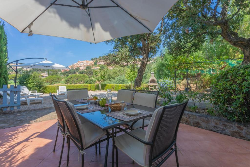 a table with chairs and an umbrella on a patio at Bel appartement 4p St-Maxime in Sainte-Maxime