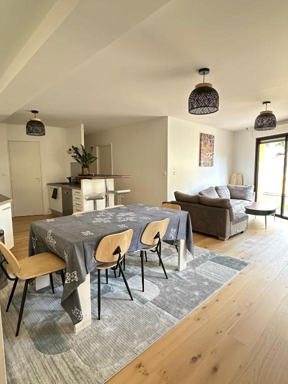 un salon avec une table, des chaises et un canapé dans l'établissement Charmant T3 à la plage, à Seignosse