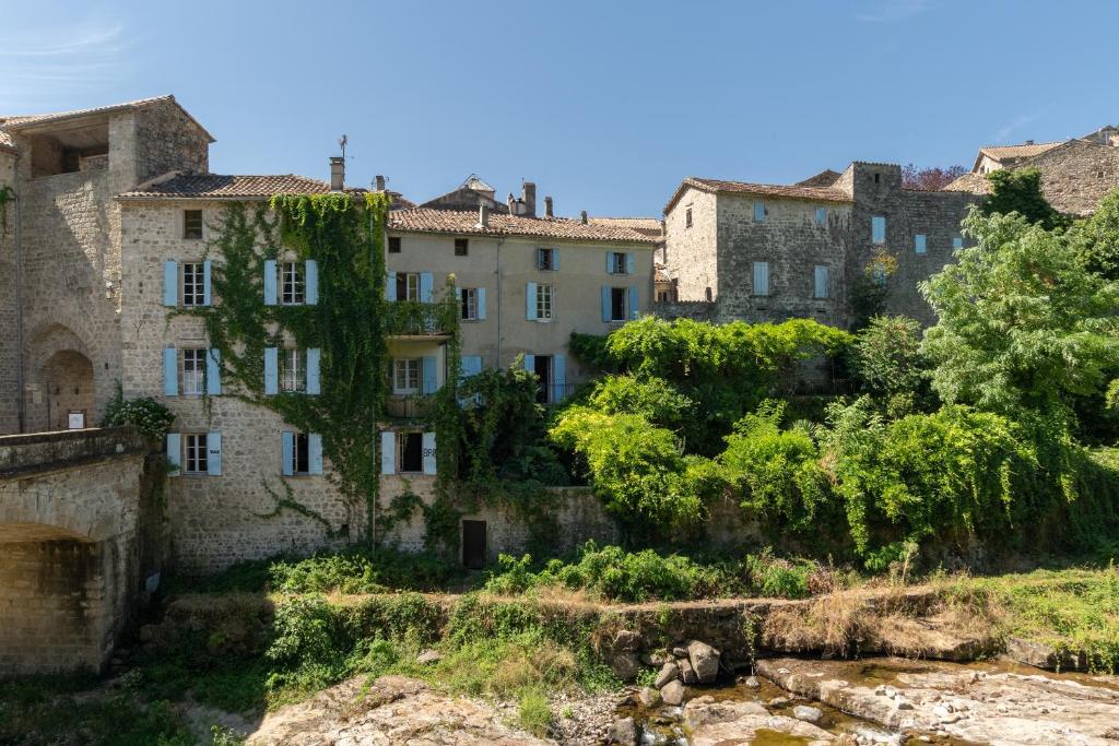 un groupe de bâtiments dans une ville arborée dans l'établissement Maison de Maître du domaine des Lys, à Largentière