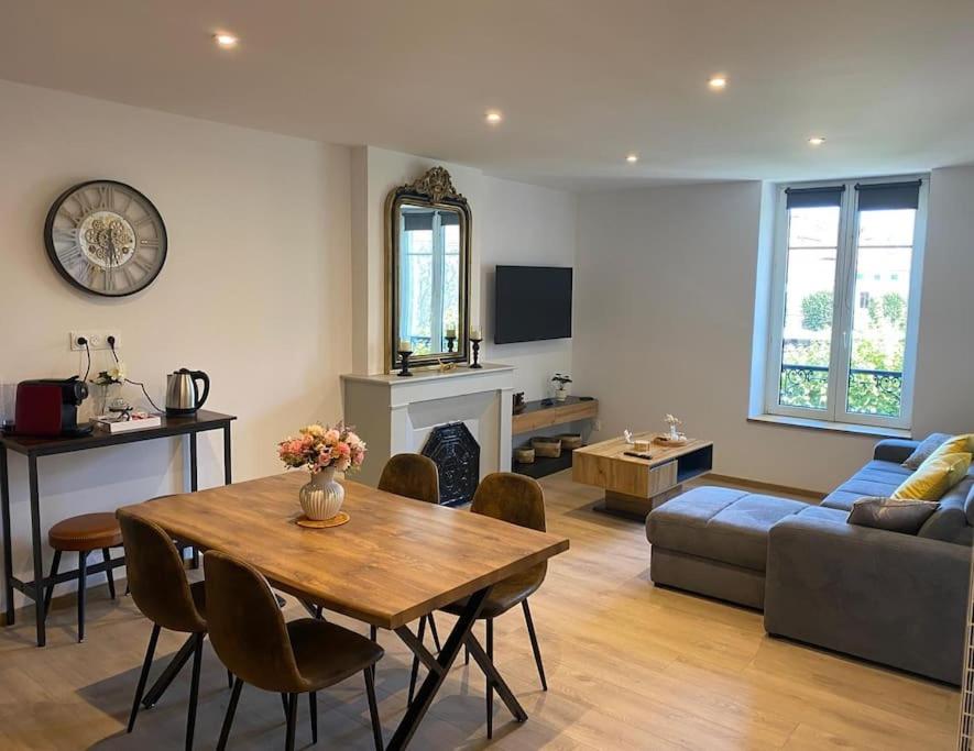 a living room with a table and a couch at Le Bellevue in Nancy