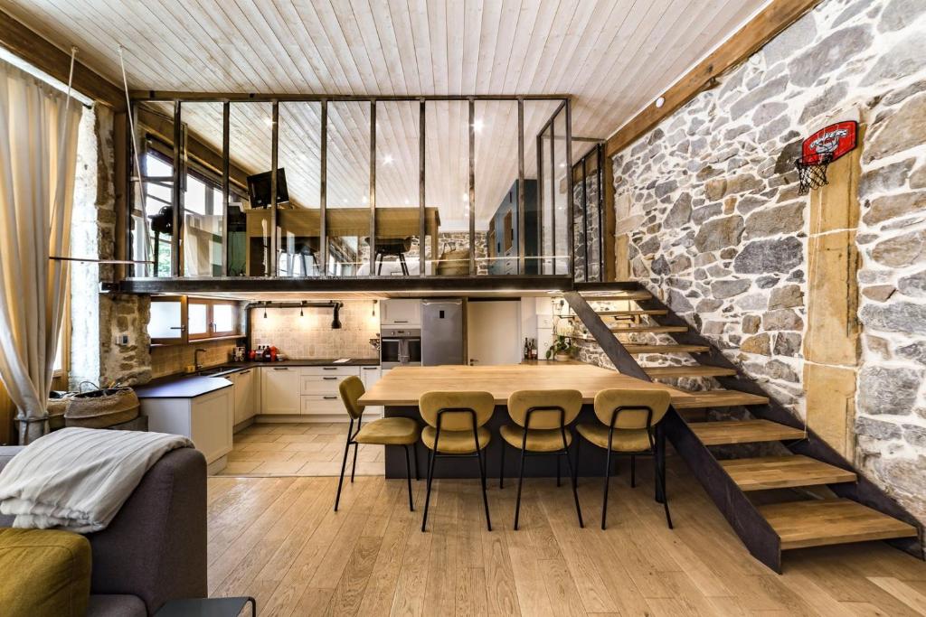 une cuisine et une salle à manger avec un mur en pierre dans l'établissement Le duplex des pentes AIL, à Lyon