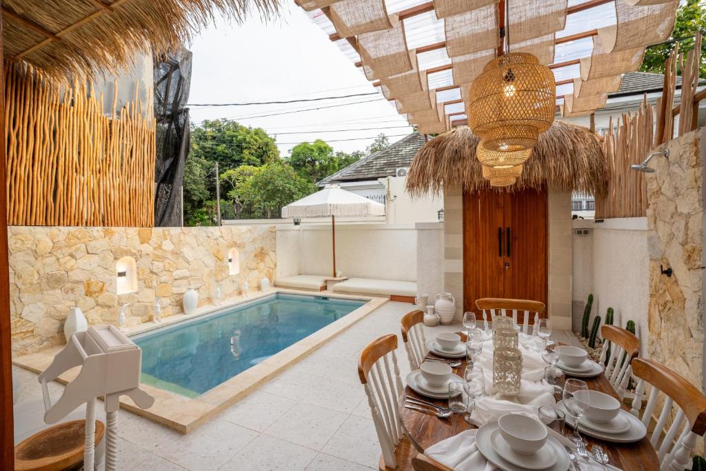 a dining room with a table and a swimming pool at Villa Tropical Terrazzo 2BR Private Pool in Jimbaran