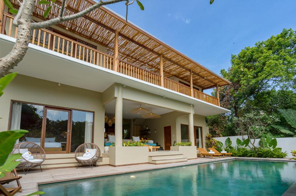 a villa with a swimming pool and a house at Villa Canopy at Nyanyi in Tabanan