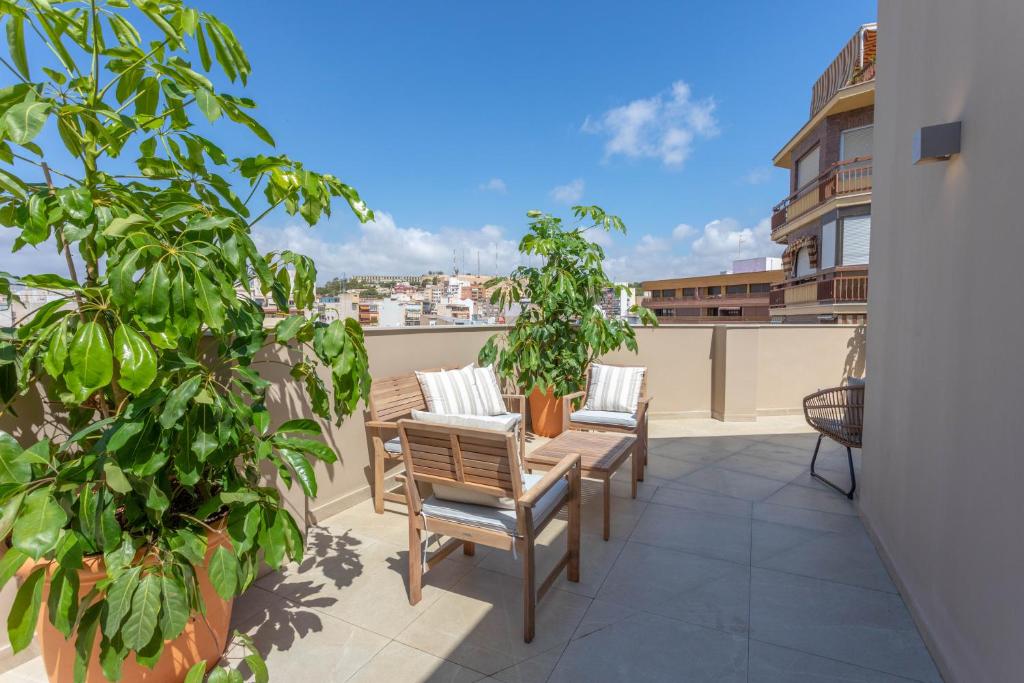 a patio with chairs and plants on a balcony at Reina Victoria El Mercado in Alicante
