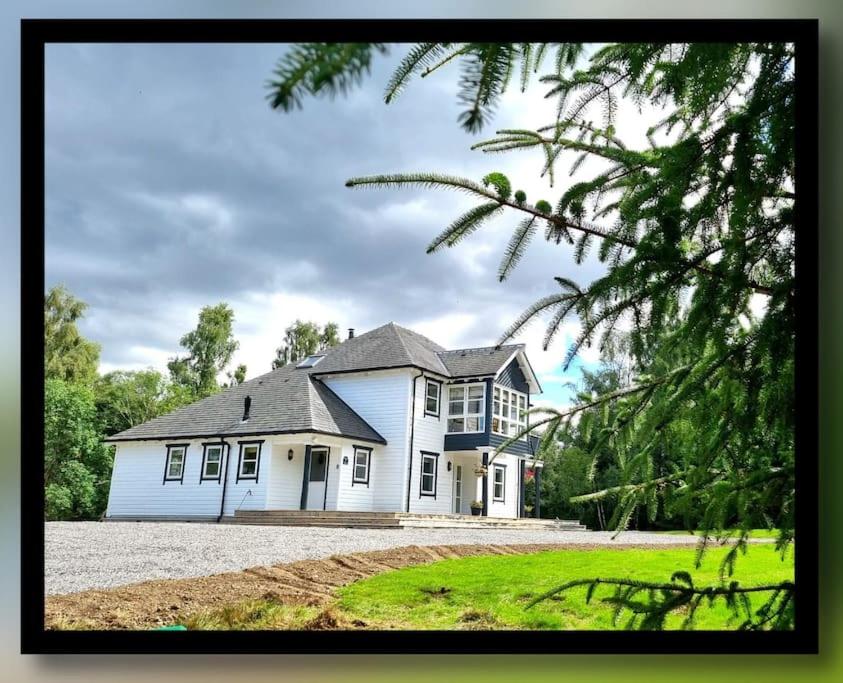 a large white house with a large yard at Heath House Loch Ness in Errogie