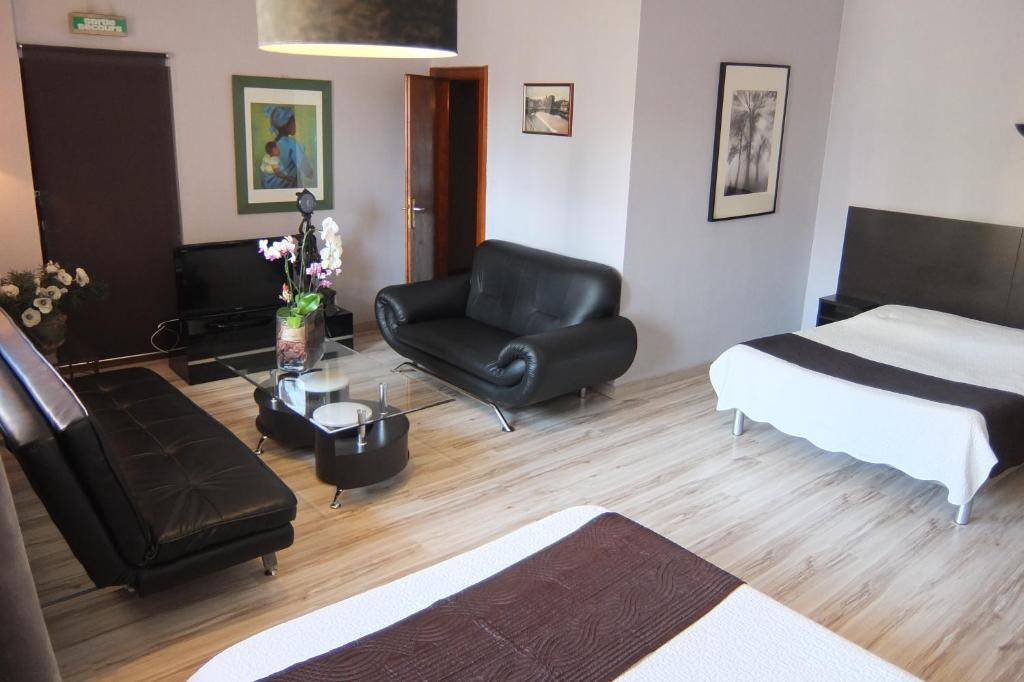 un soggiorno con letto e sedia di Hôtel-Restaurant du Soleil Levant a Sarrebourg