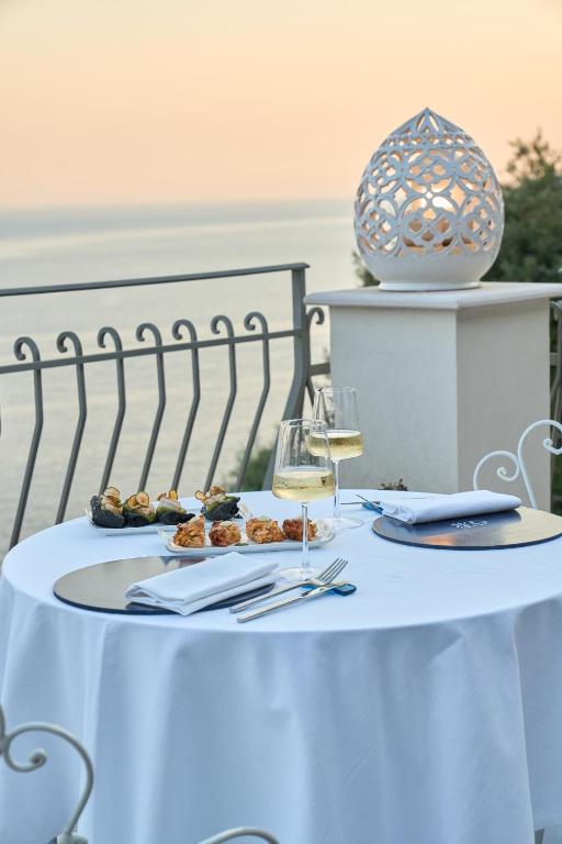 a white table with food and a glass of wine at Hotel Villa Pandora in Maiori