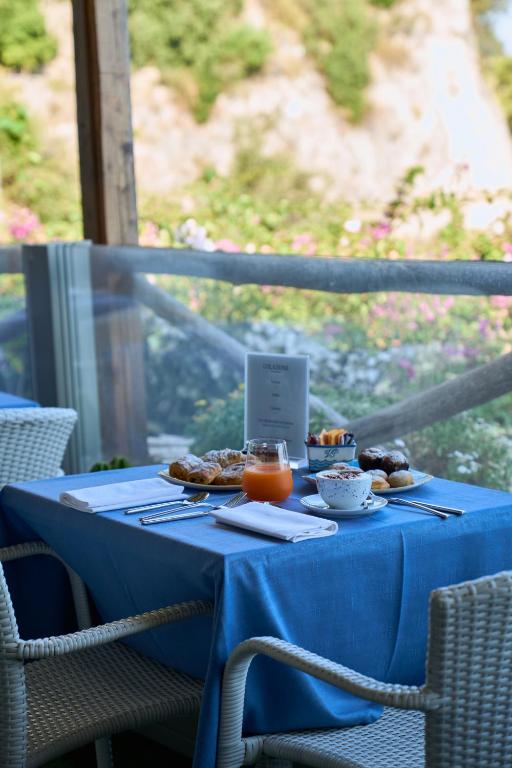a table with a blue table cloth and food on it at Hotel Villa Pandora in Maiori