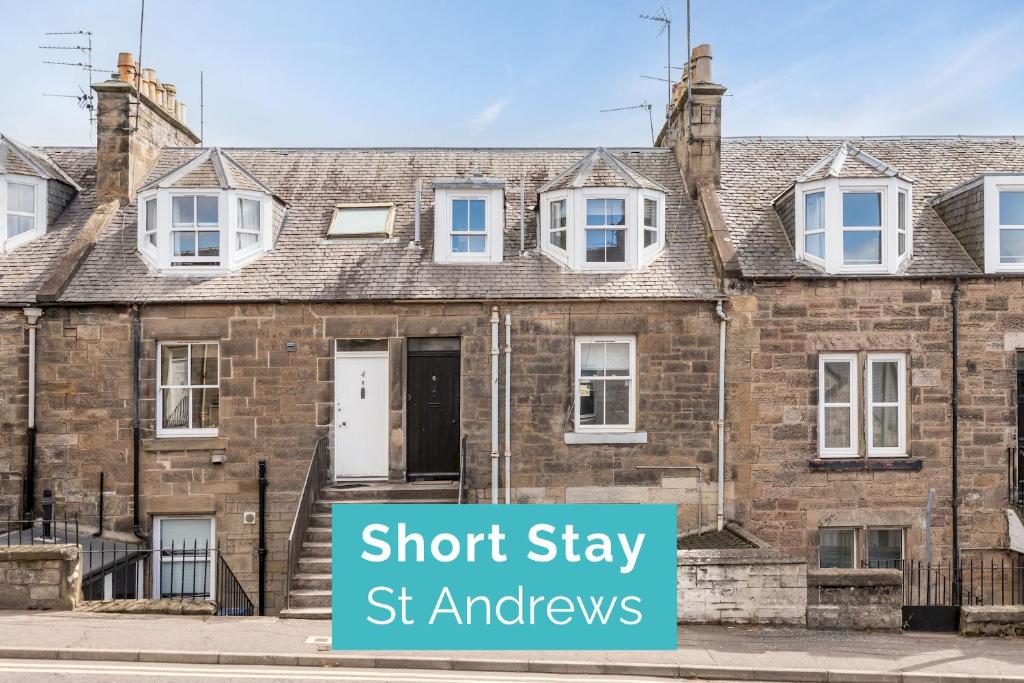 a brick house with a sign that reads short stay st enaples at Kinness Place - No 6 in St. Andrews