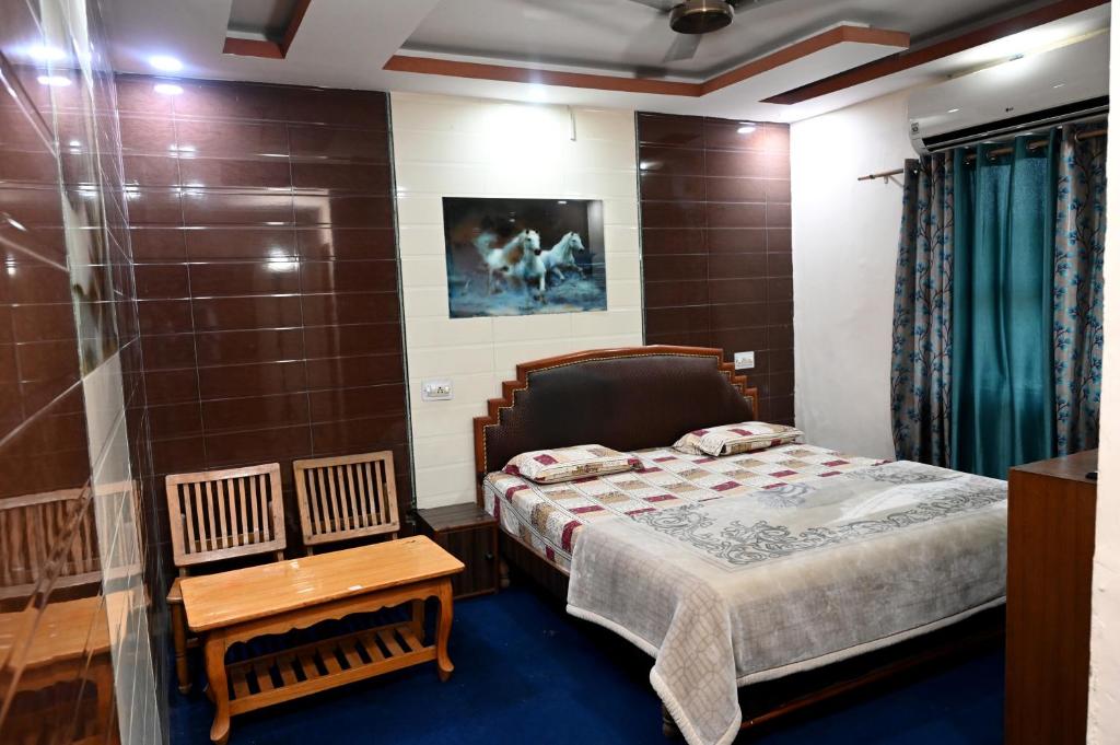a small bedroom with a bed and a table at Hotel Sunrise in Chandīgarh