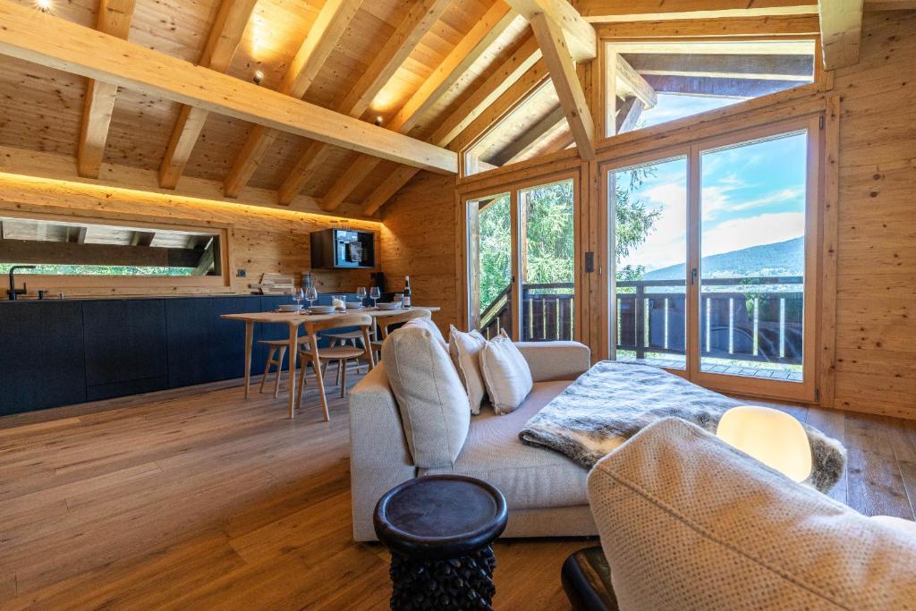 a living room with a couch and a kitchen withwindows at Base Camp COSY chalet 4 personnes in Les Mosses