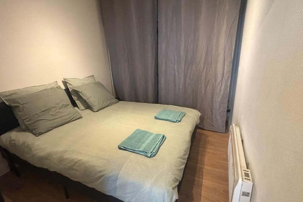 - un petit lit avec 2 serviettes dans l'établissement Le bel Appart, à Dunkerque