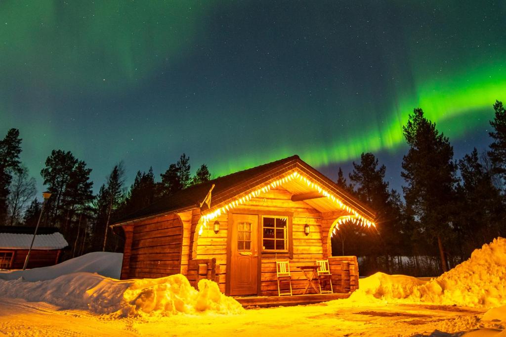 a log cabin with the aurora in the sky at Camping Fredrika-Braber in Fredrika