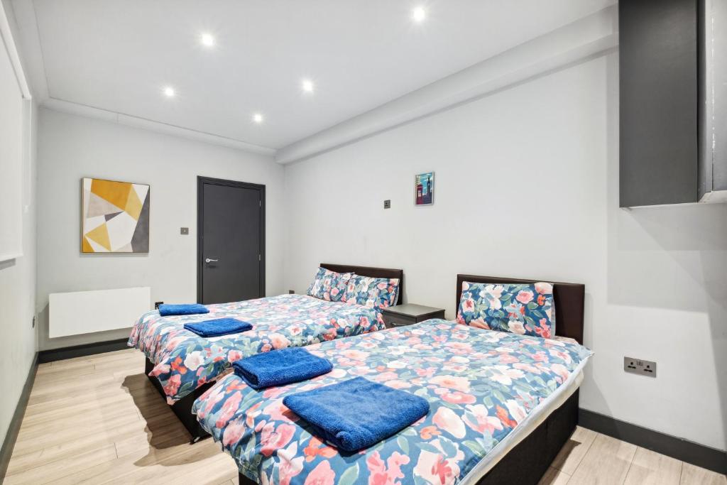 ロンドンにあるCozy London Apartmentのベッドルーム1室(青い枕のベッド2台付)