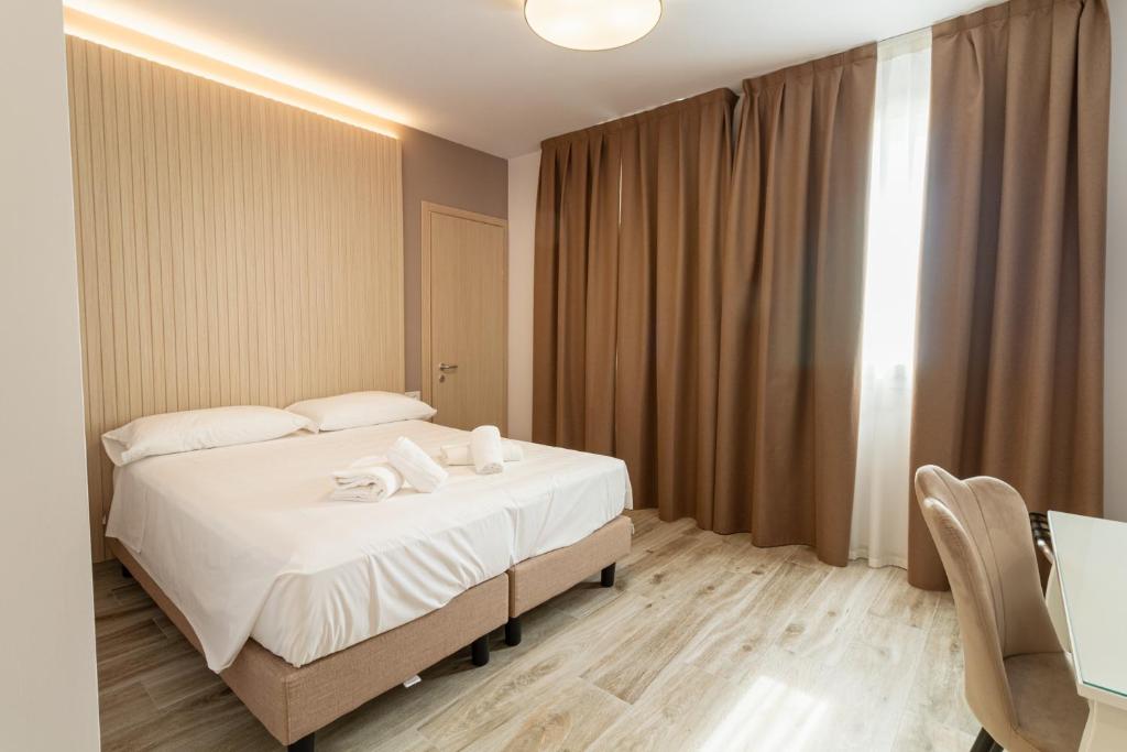 ein Schlafzimmer mit einem Bett mit weißen Laken und Kissen in der Unterkunft I Campi Wine Relais in Ronchi