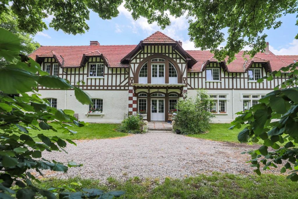 a large white house with a red roof at Chalet des longschamps in Argoeuves