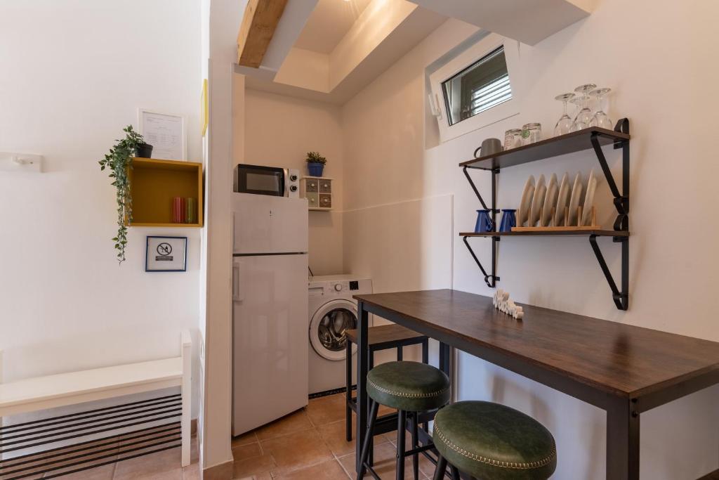 kuchnia ze stołem i stołkami w pokoju w obiekcie Apartman GREEN & BLUE w Novalji
