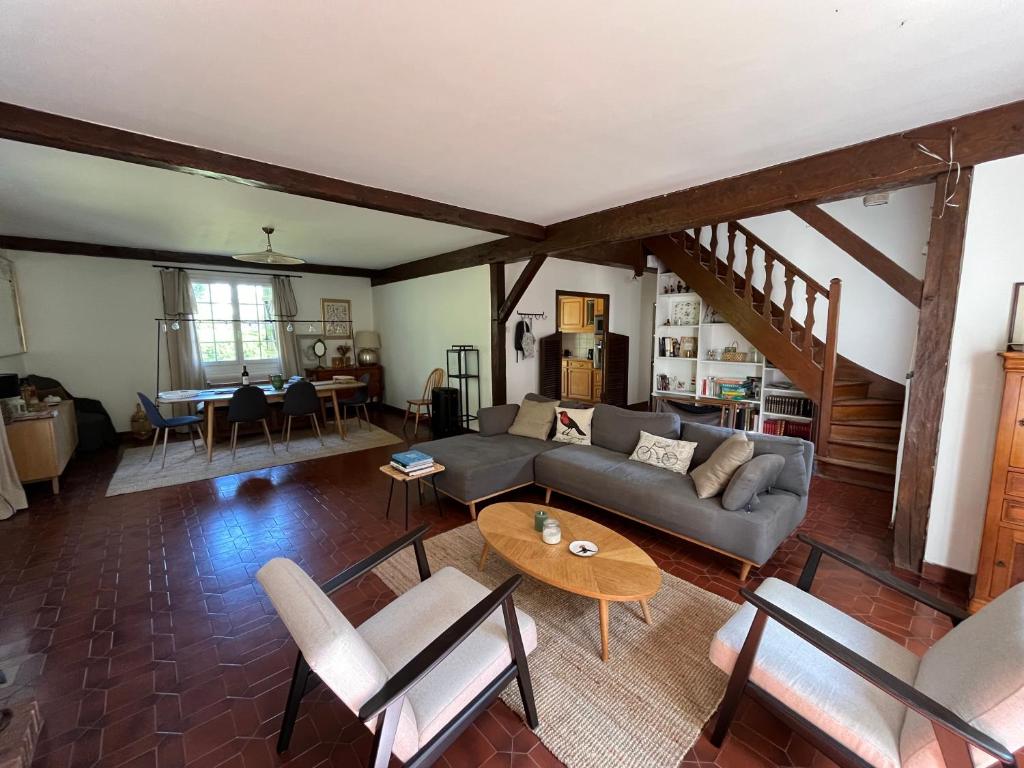 un salon avec un canapé et une table dans l'établissement Maison familiale, grand jardin, à La Ferté-Imbault