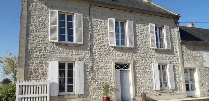 a stone house with white windows and a white fence at La Maison Poésie in Blay
