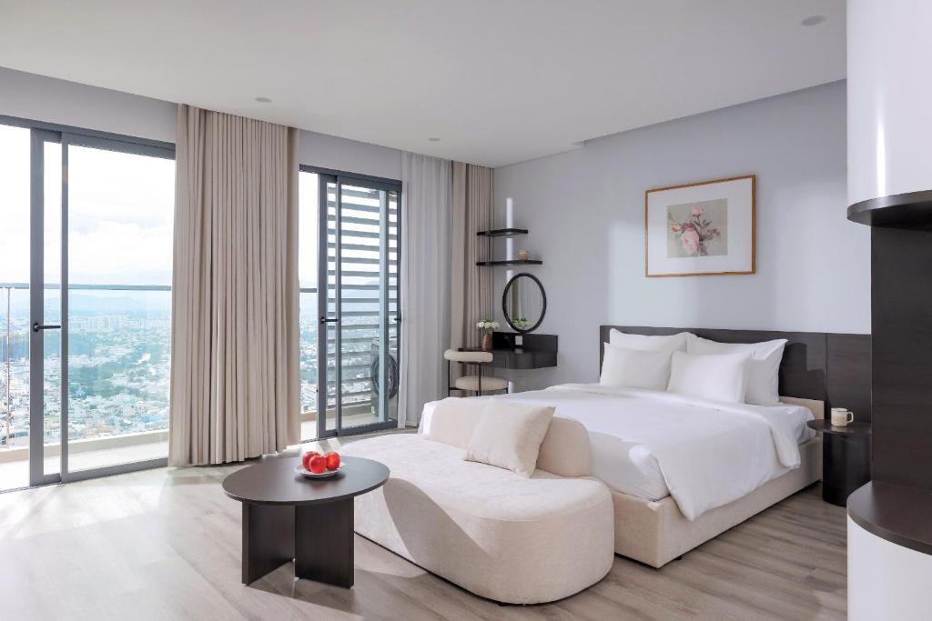 a bedroom with a white bed and a white couch at MARINA SUITES Apartment in Nha Trang