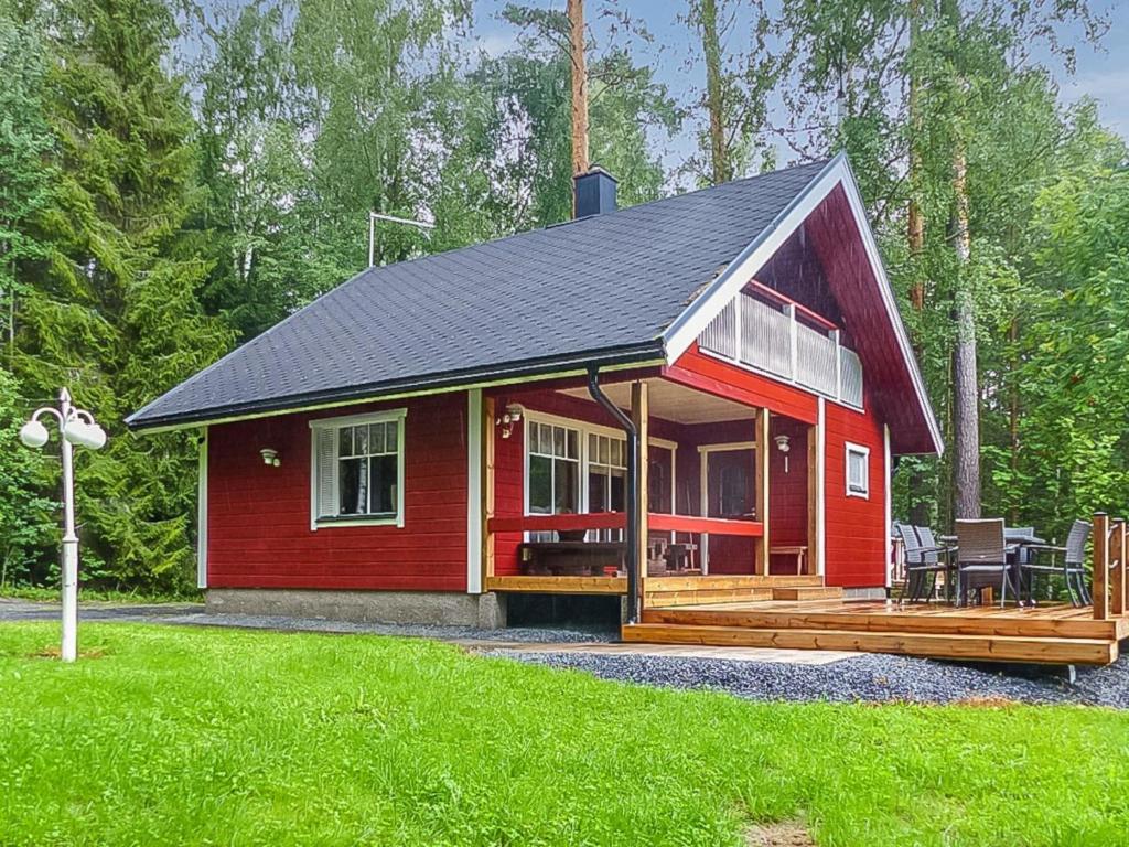 eine rote Hütte mit einer Veranda und einer Terrasse in der Unterkunft Holiday Home Pinea by Interhome in Niittymaa