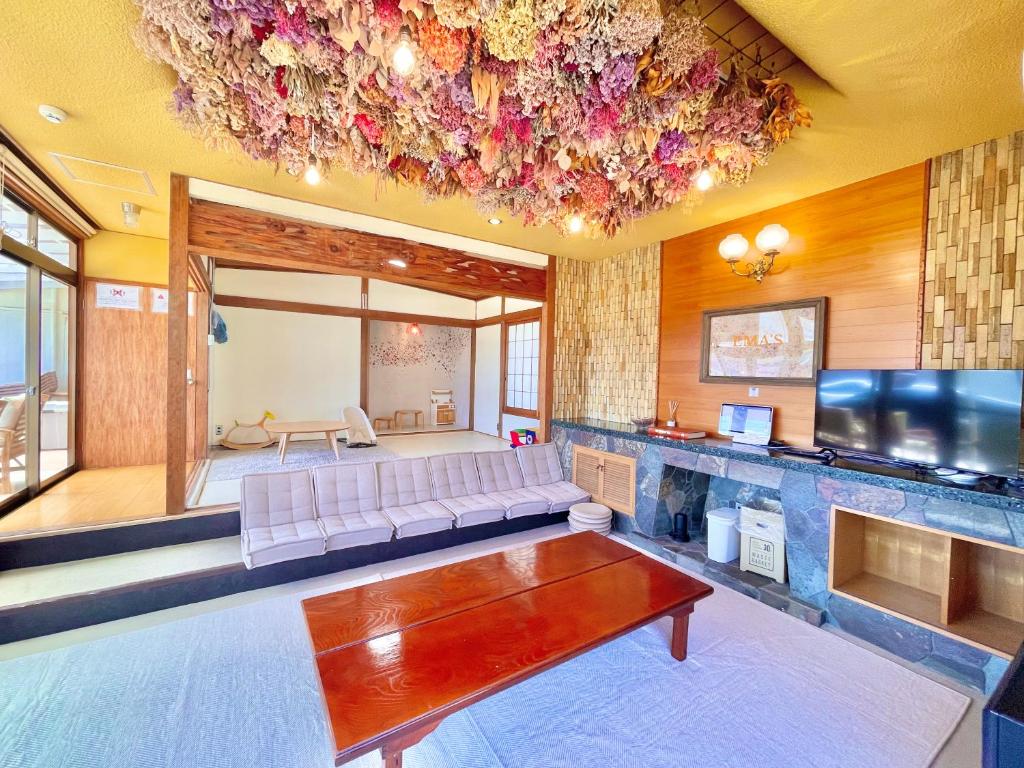 ein Wohnzimmer mit Couch und Flachbildfernseher in der Unterkunft 香川県高松市中心部で駐車6台無料の家族向けゲストハウス in Takamatsu