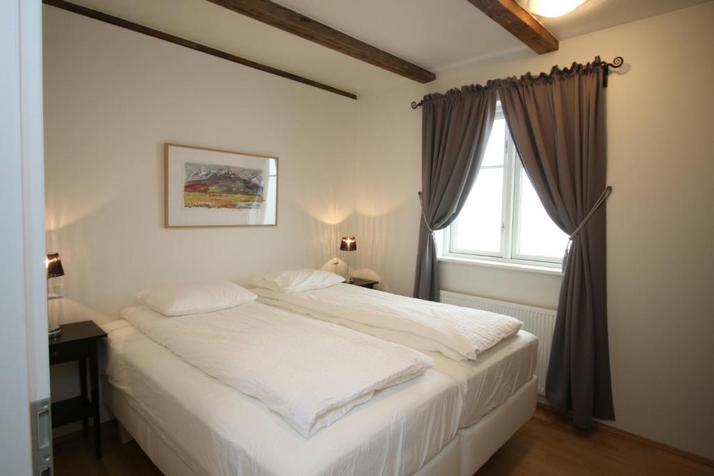 een wit bed in een slaapkamer met een raam bij Acco Ice Apartments in Akureyri